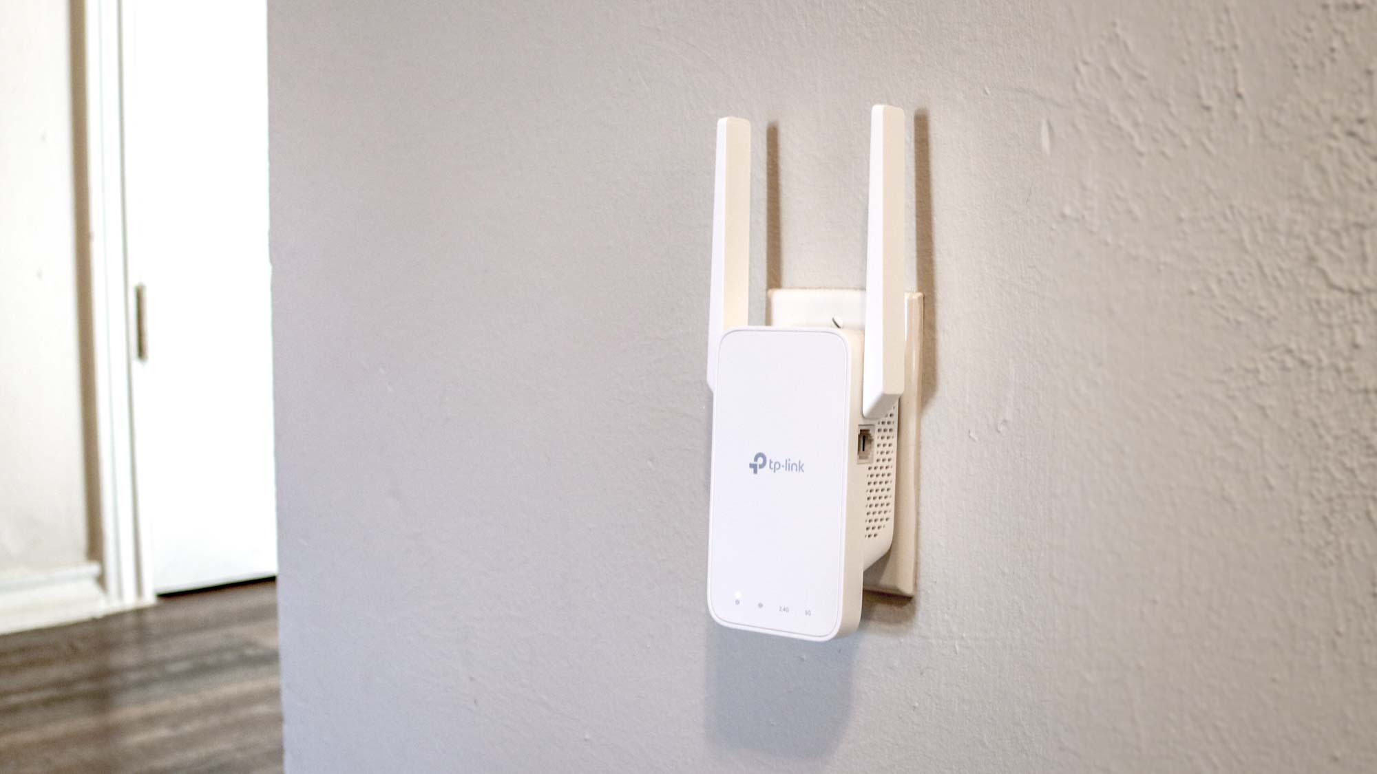 Un repetidor Wi-Fi conectado a un tomacorriente de pared