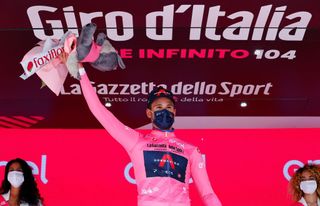 Team Ineos rider Italys Filippo Ganna wearing the overall leaders pink jersey celebrates on the podium after winning the first stage of the Giro dItalia 2021 cycling race a 86 km individual time trial on May 8 2021 in Turin Photo by Luca Bettini AFP Photo by LUCA BETTINIAFP via Getty Images