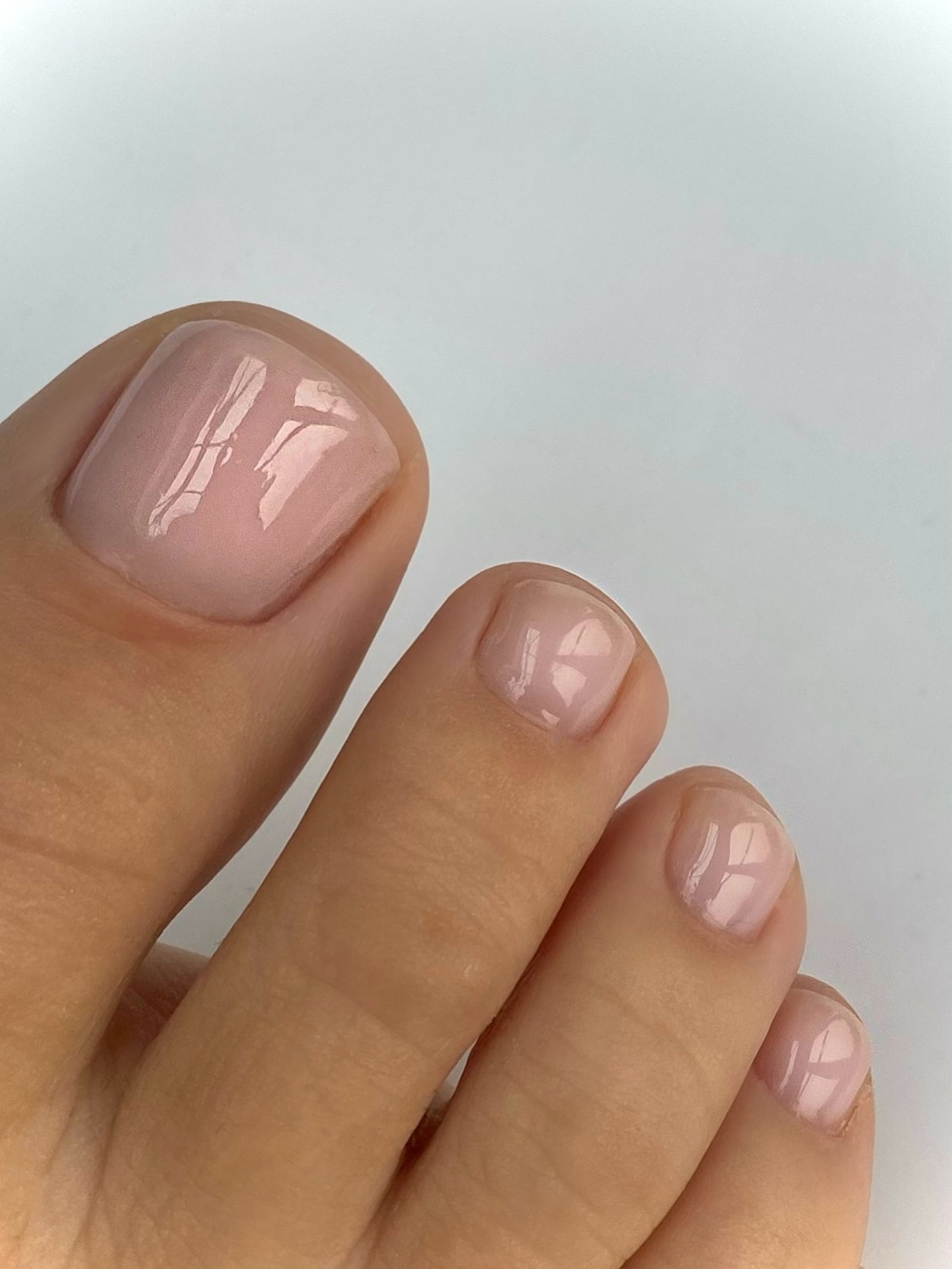 A close-up picture of a clear, shiny pedicure