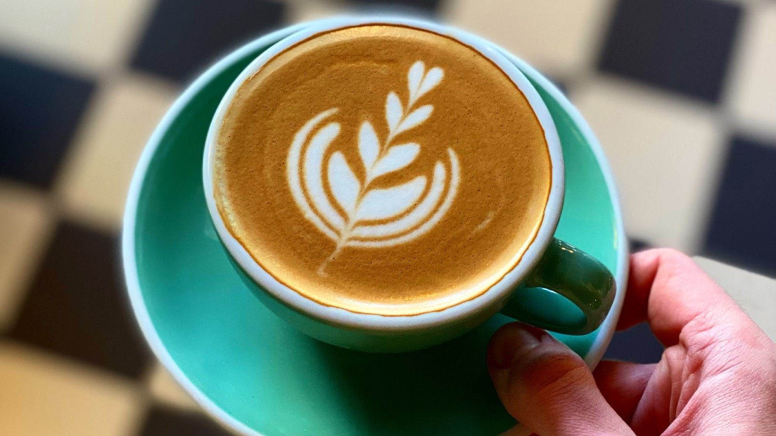 Stack tulip latte art by Ben Lewis in turquoise cup with saucer