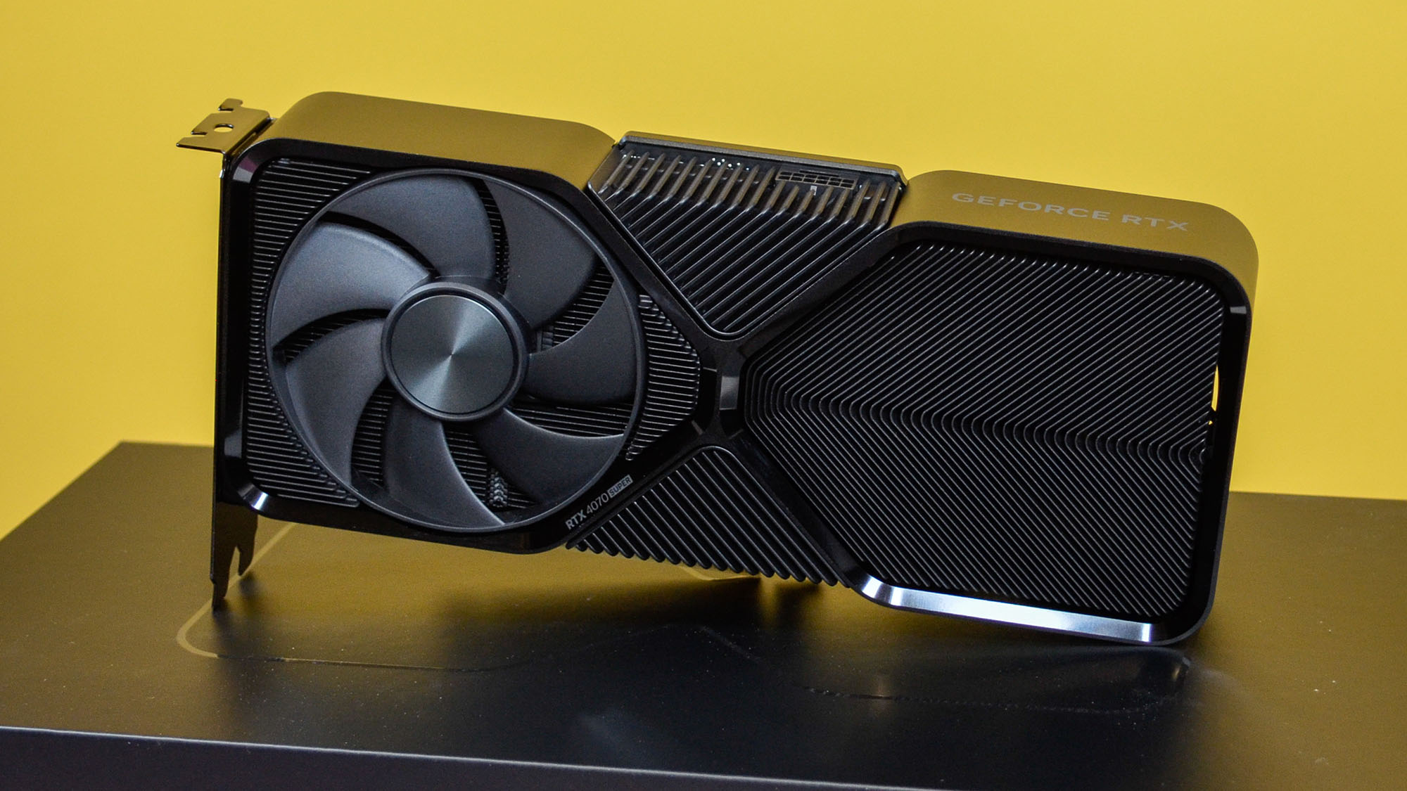 An Nvidia GeForce RTX 4070 Super on a desk in front of a yellow background