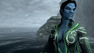 A blue sea spirit stands by the water