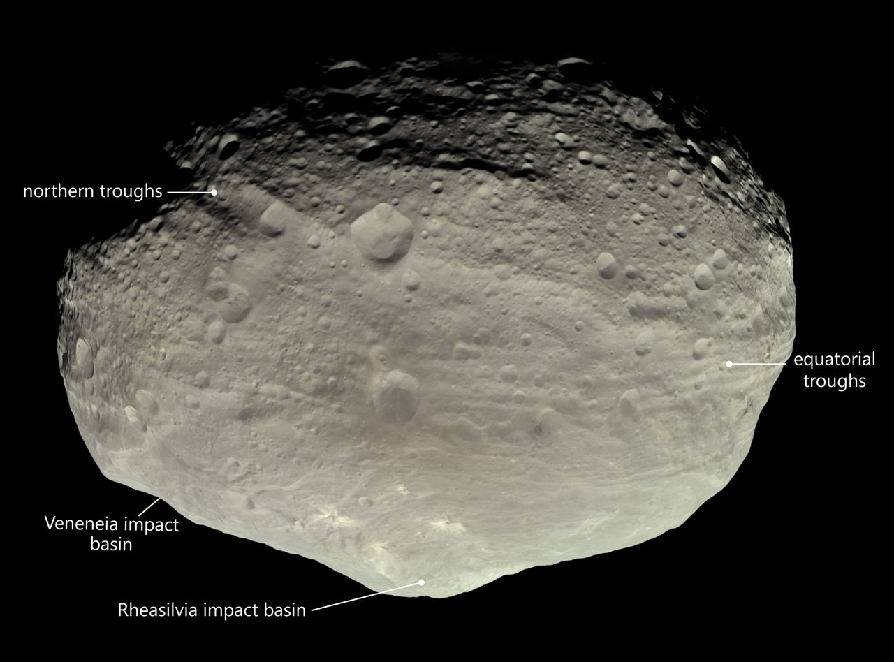 An image of the asteroid Vesta shows large impact basins and troughs.