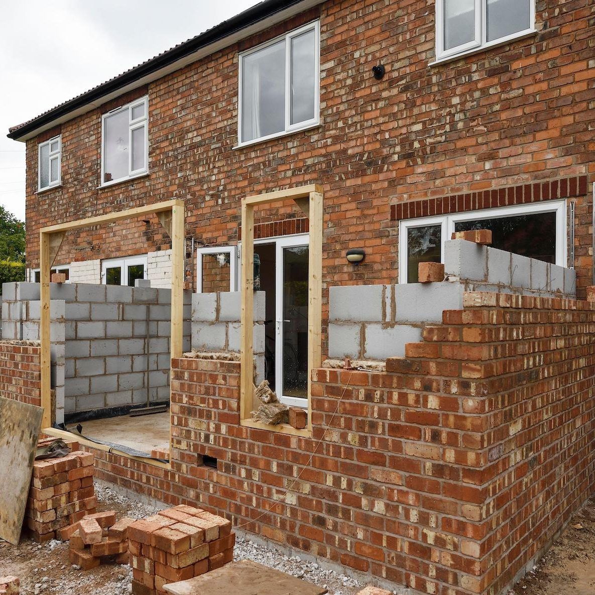 building a house with brick wall glass window and wooden frame