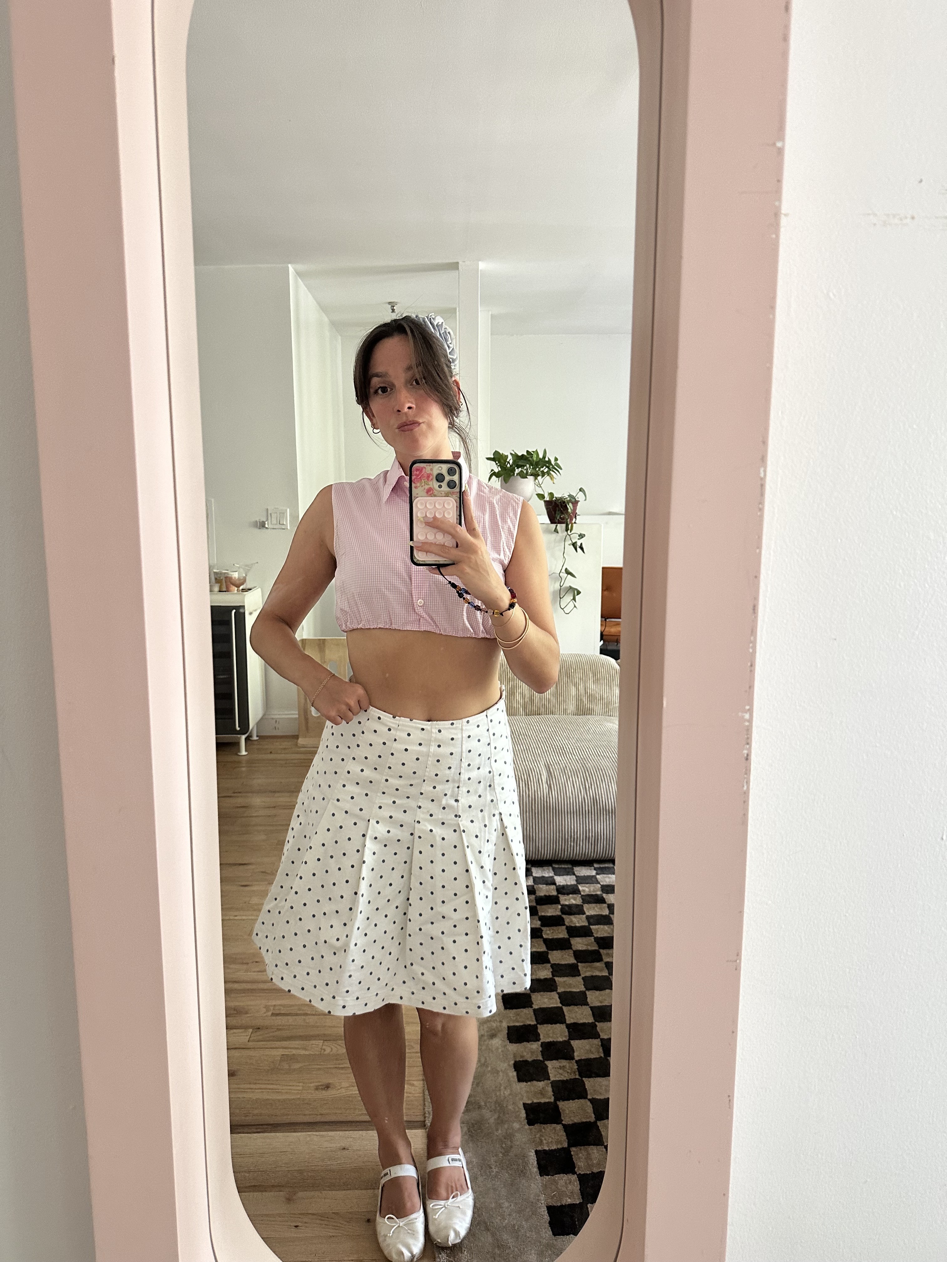 Tara Gonzalez taking selfies in a polka dot skirt.