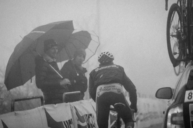 Fans cheer on a rider through the fog.