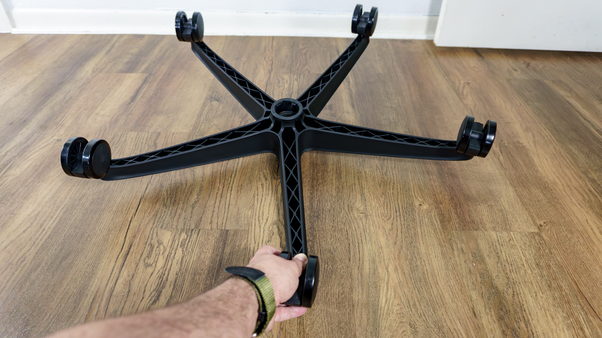 A person installing the casters on the base of the LiberNovo Omni SE office chair
