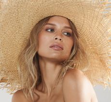 model wearing brown eyeliner and a straw hat