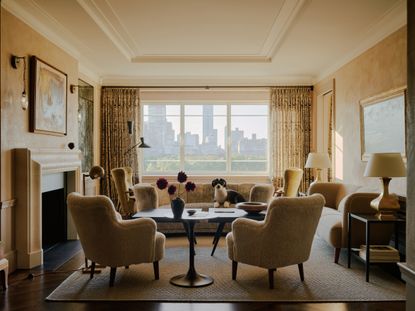 A room with matte Venetian plaster walls framed a large window with a view of Manhattan