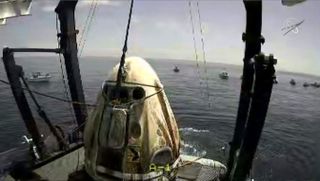 SpaceX's Crew Dragon Endeavour with astronauts Bob Behnken and Doug Hurley aboard is hoisted onto the deck of the recovery ship GO Navigator off the coast of Pensacola, Florida on Aug. 2, 2020.