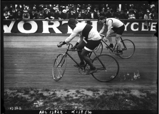 A black-and-white side-on photo of Marshall "Major" Taylor riding a bike in a bike race.