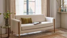 A cream, boucle sofa from Atkin & Thyme in a modern, cream living room.