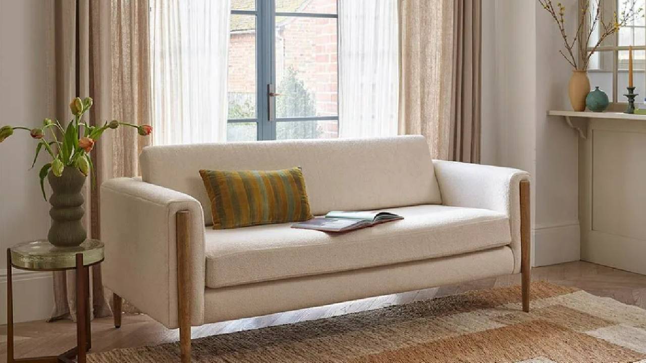 A cream, boucle sofa from Atkin & Thyme in a modern, cream living room. 