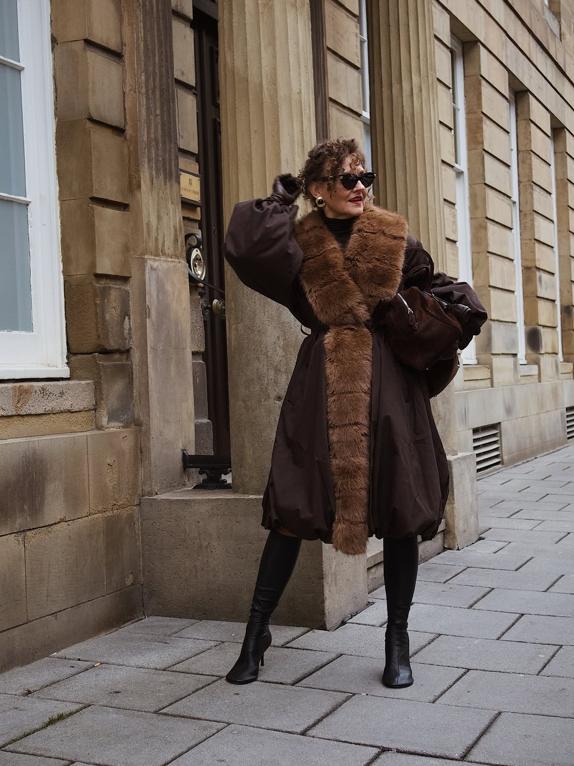 Renia Jas wears black boots faux fur coat