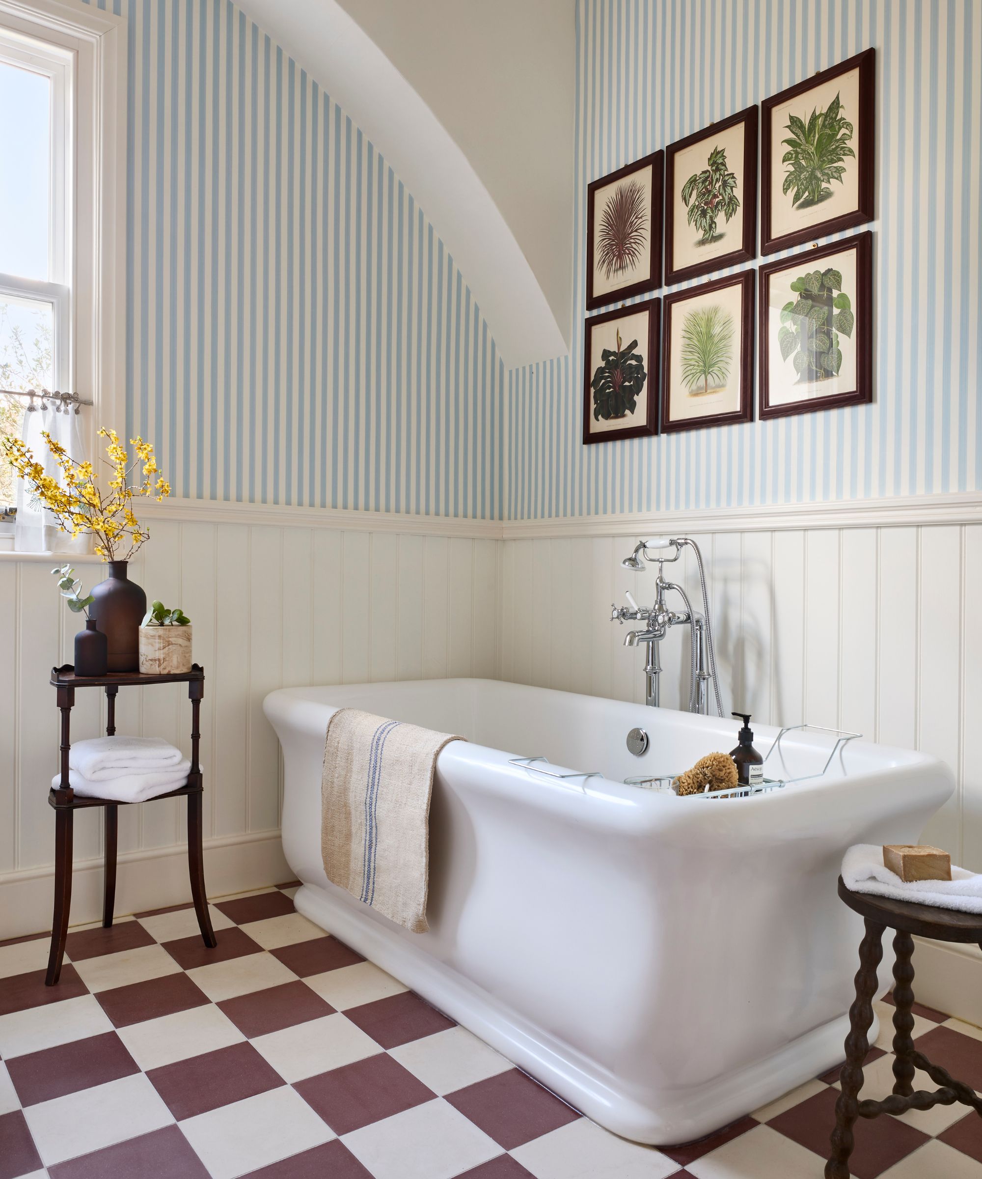 blue stripe wallpaper in a traditional bathroom with checkerboard floor tiles and freestanding tub