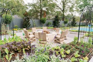 an outdoor seating area with vegetable beds