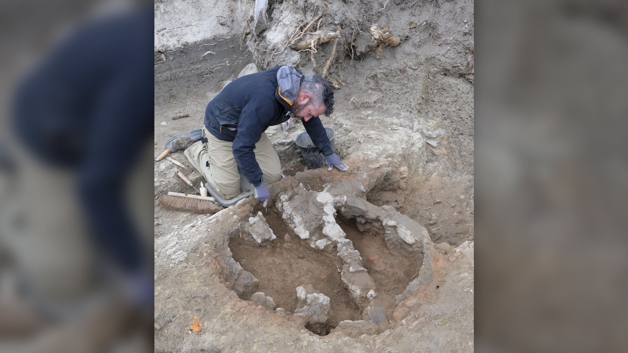 A man excavates a first century A.D. potter's kiln.
