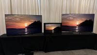 The Sony Bravia 9 II and Bravia 9 TVs, and the Sony BVM-HX3110 mastering monitor, photographed on a black desk, with Sony demo footage on the screens
