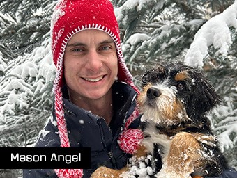 a man wearing a red toboggin and holding a dog