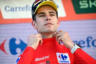 Overall ranking leader Team Visma&#039;s Wout van Aert puts the red jersey on as he celebrates on the podium after winning the stage 3 of La