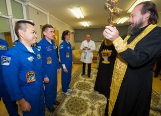A Russian orthodox priest blesses the three Expedition 32 crew members launching to the International Space Station on July 15, 2012.