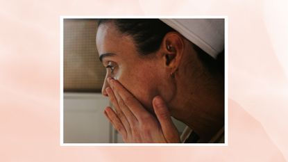 A close up of a woman wearing a towelled headband touching her nose and cheeks with her hands/ in a pink watercolour paint-style template