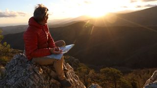 how to orientate a map: hiker with a map and compass