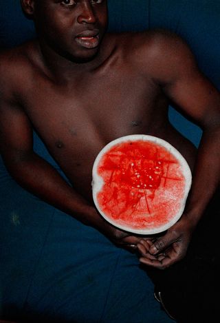 Naked man holding a fruit