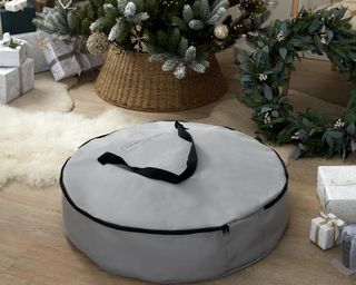 The White Company Greenery Storage Bag, rounded and grey, in front of tree