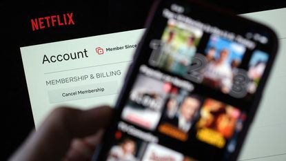 person looking at Netflix streaming selections on phone and account on laptop