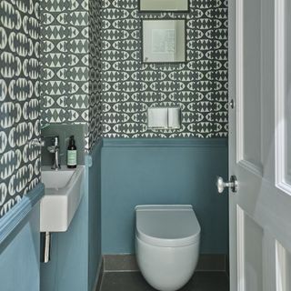 downstairs toilet with grey aztec wallpaper and blue wall panelling