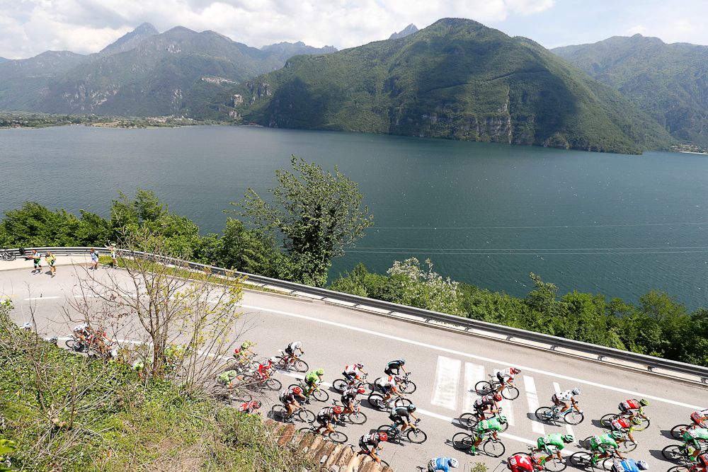 The peloton rides along the lake Idro during the 17th stage of the 99th Giro d'Itali