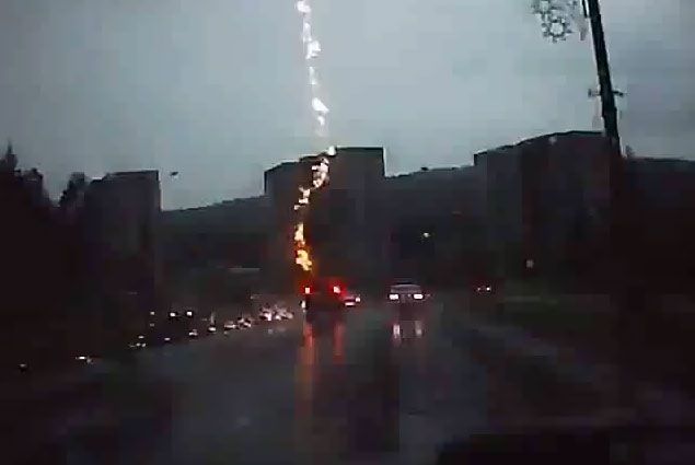 A screengrab from the YouTube video that apparently depicts an SUV being struck by lightning.