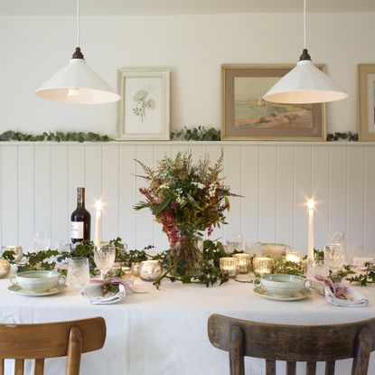 dining room with white wood panel walls and table set for christmas dinner