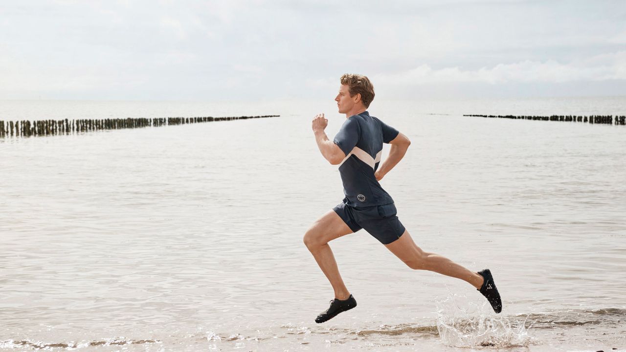 person runnig on the sea front wearing Vivobarefoot running shoes