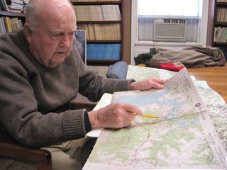 Preparing for a flight along the Rappahannock River, Mitchell Byrd checks a topographical map showing last year's eagle nest sites. Bald eagles often repair and reuse nests from the previous year.