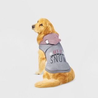 A dog posing from the back with its head looking over its shoulder wearing a gray hooded sweater that says 'Let it snow', for Christmas sweaters for dogs.