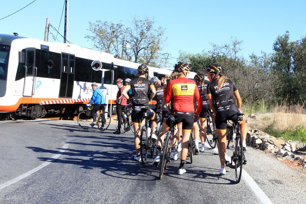 The Wiggle Honda team waits for the train to pass while out training