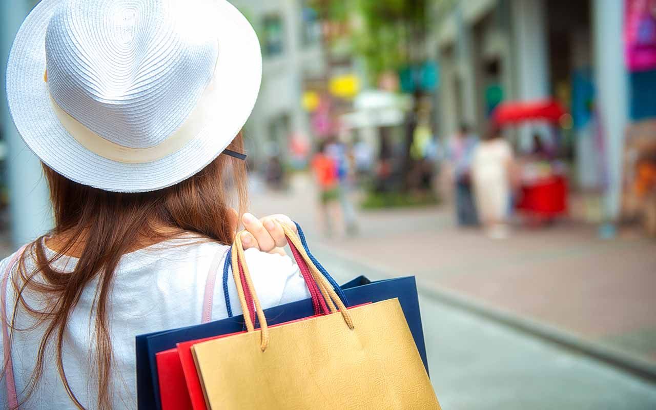 Asian Woman Holding Shopping Bags In Shopping Mall