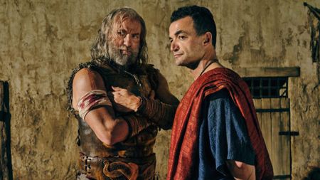 Korris and Ashur look at something offscreen