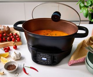 A black slow cooker filled with stew
