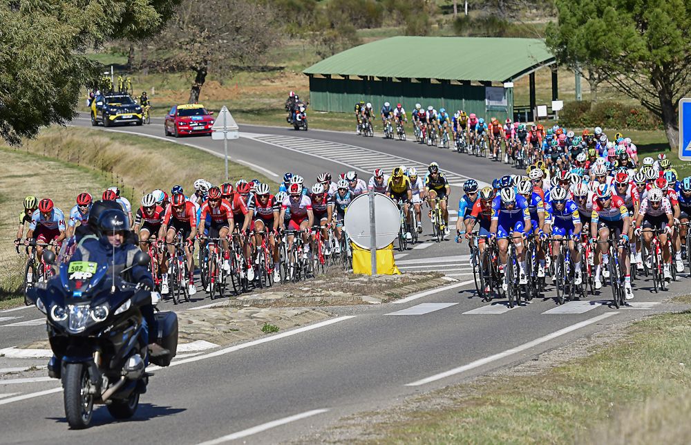 The paris-Nice peloton divides on either side of the road furniture