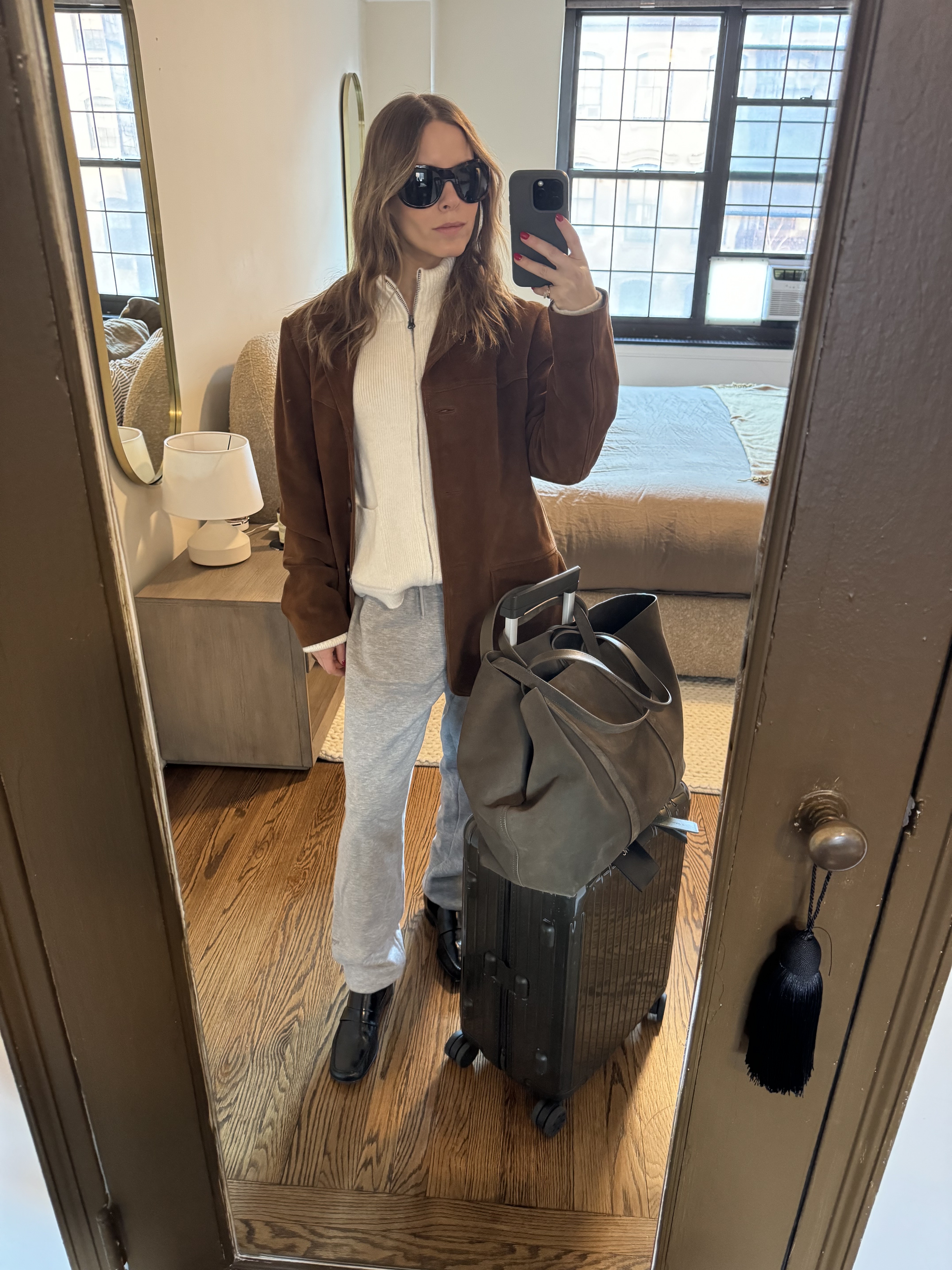 Associate fashion editor Nikki wears a suede blazer, white sweater, gray sweatpants, and black loafers.