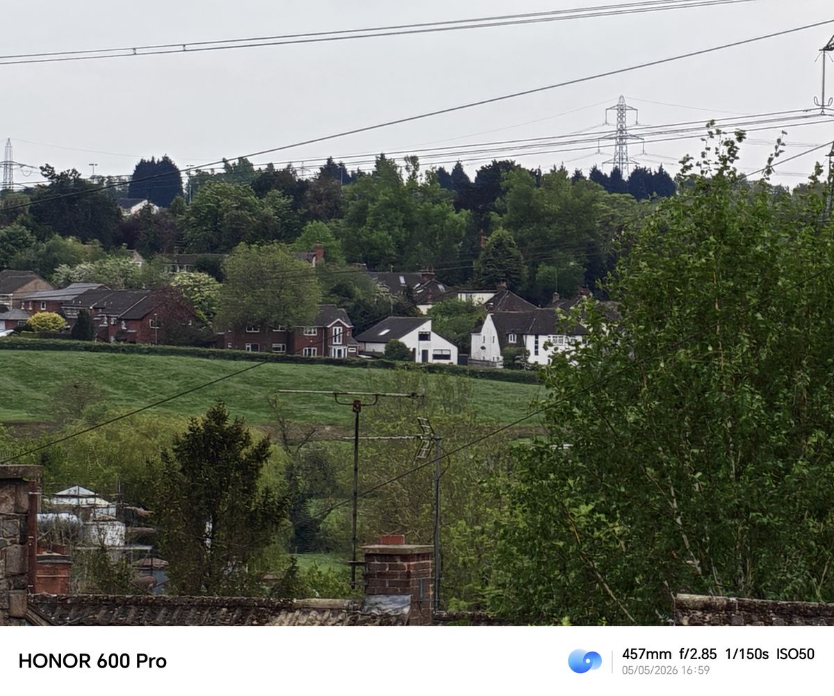 Long-range zoom shot of distant houses and trees taken with the Honor 600 Pro