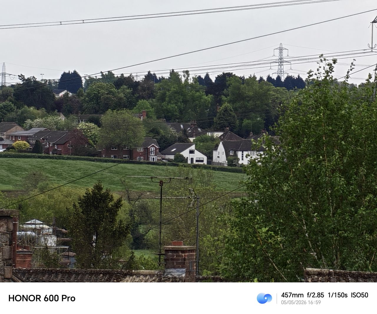 Long-range zoom shot of distant houses and trees taken with the Honor 600 Pro