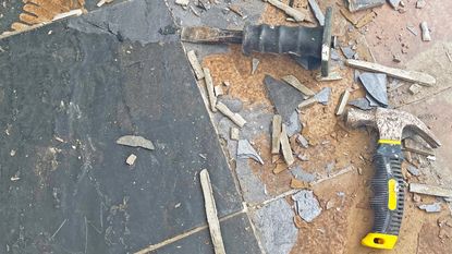 black slate floor tiles being removed with hammer and chisel
