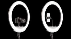 Two ring lights, one with a camera inside and the other with a phone, against a black background