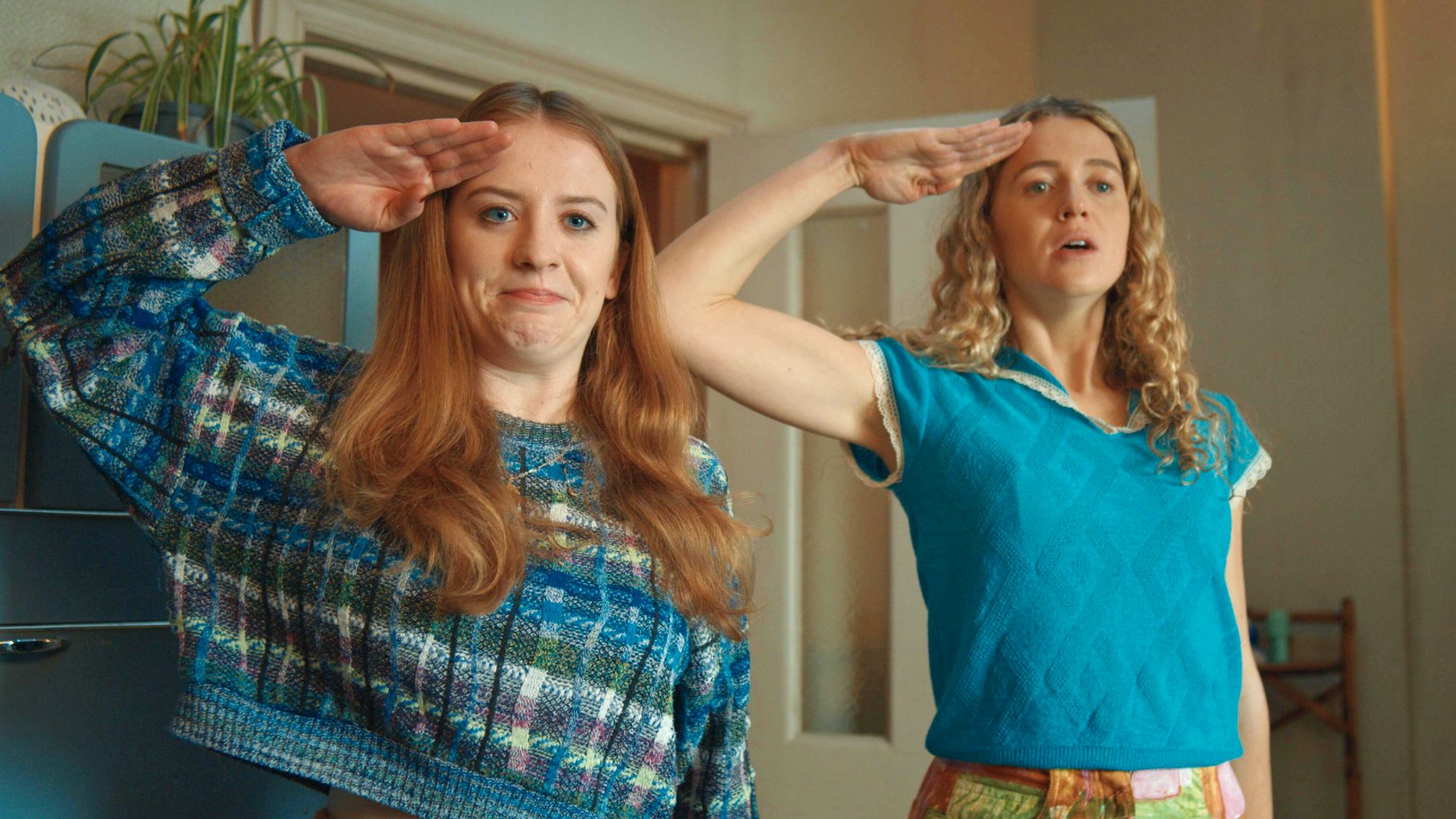 (da esquerda para a direita) Máiréad Tyers como Jen e Sofia Oxenham como Carrie saúdam Extraordinary