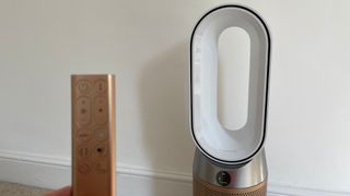 Dyson Hot + Cool Air Purifier with the remote in front of it