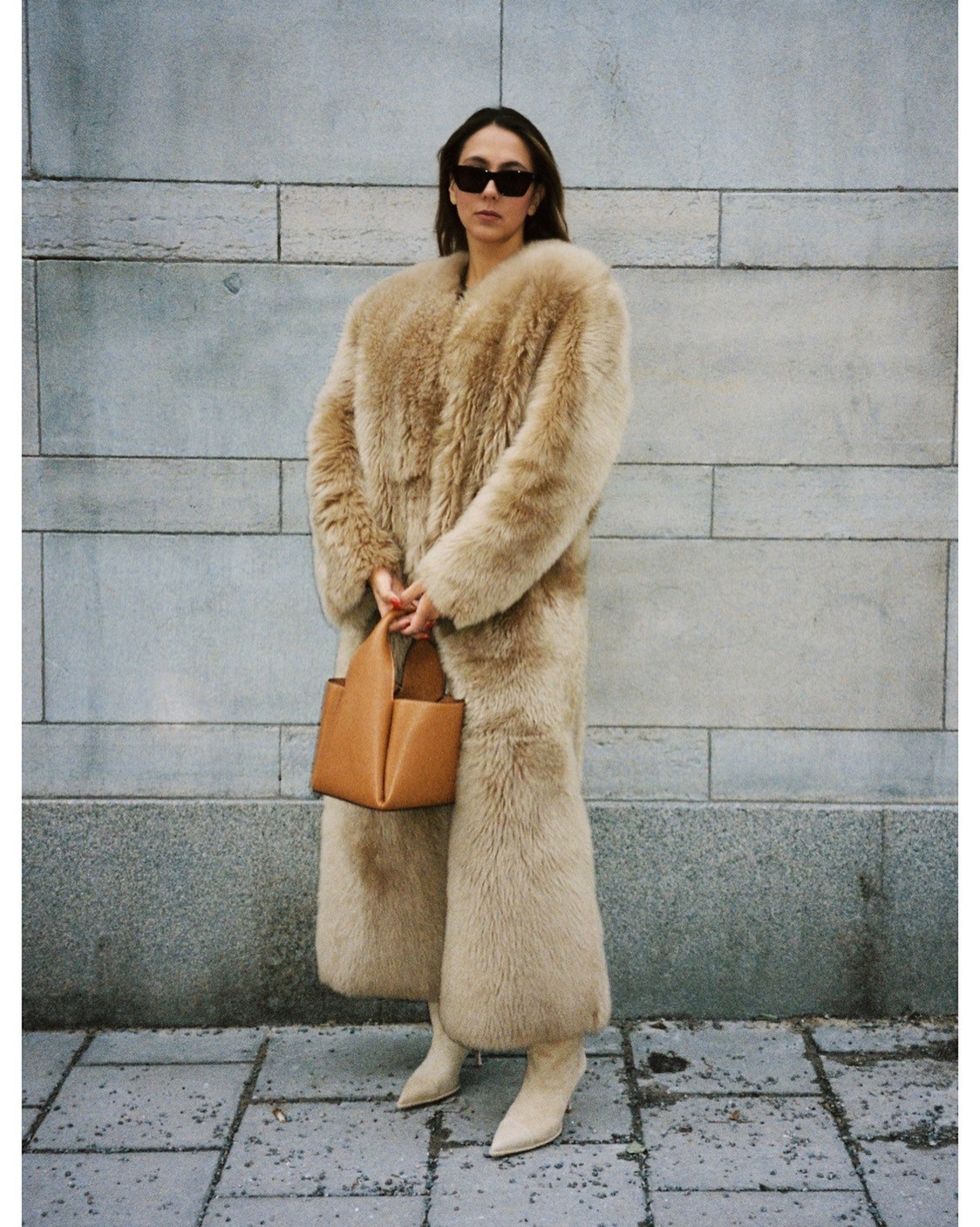 Hanna MW wearing a shearling tan coat with a brown bag and tan boots.